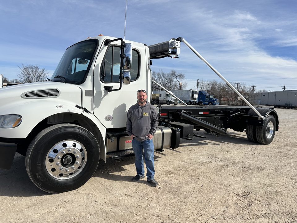 Paul standing beside a white Roll Off Operations roll-off truck