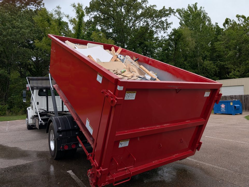 Red Roll Off Operations dumpster loaded with renovation debris